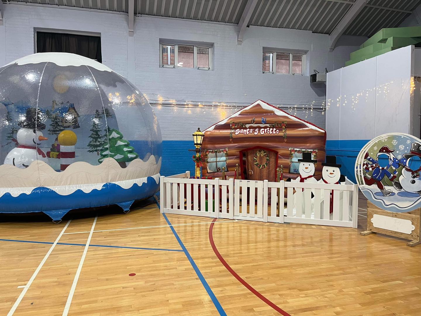 This image shows an inflatable snow globe and Santa's grotto experience supplied by SJ's Leisure in Birkenhead for a Christmas party