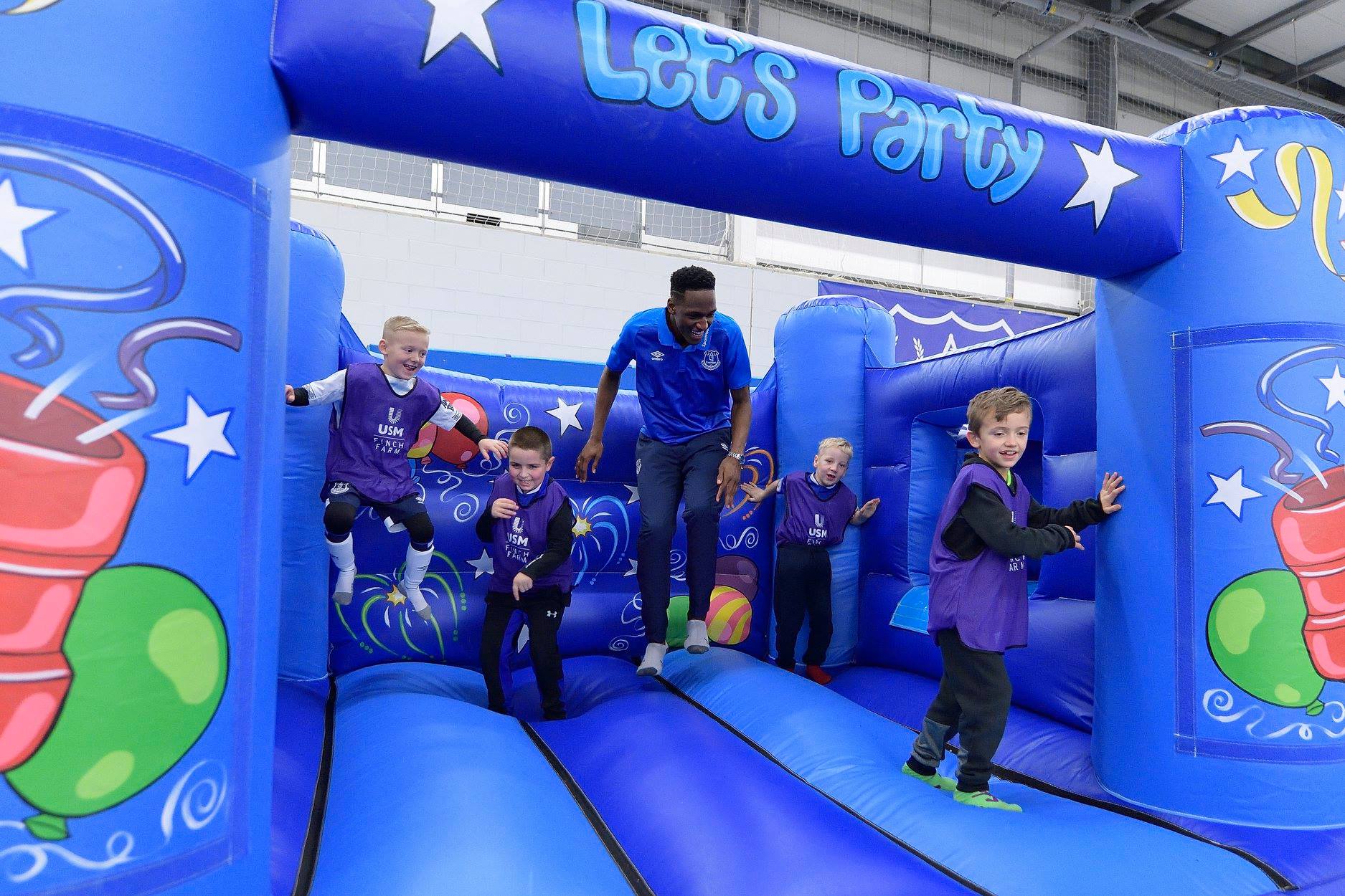 Children and Yerry Mina playing on bouncy castle at Everton Christmas Party
