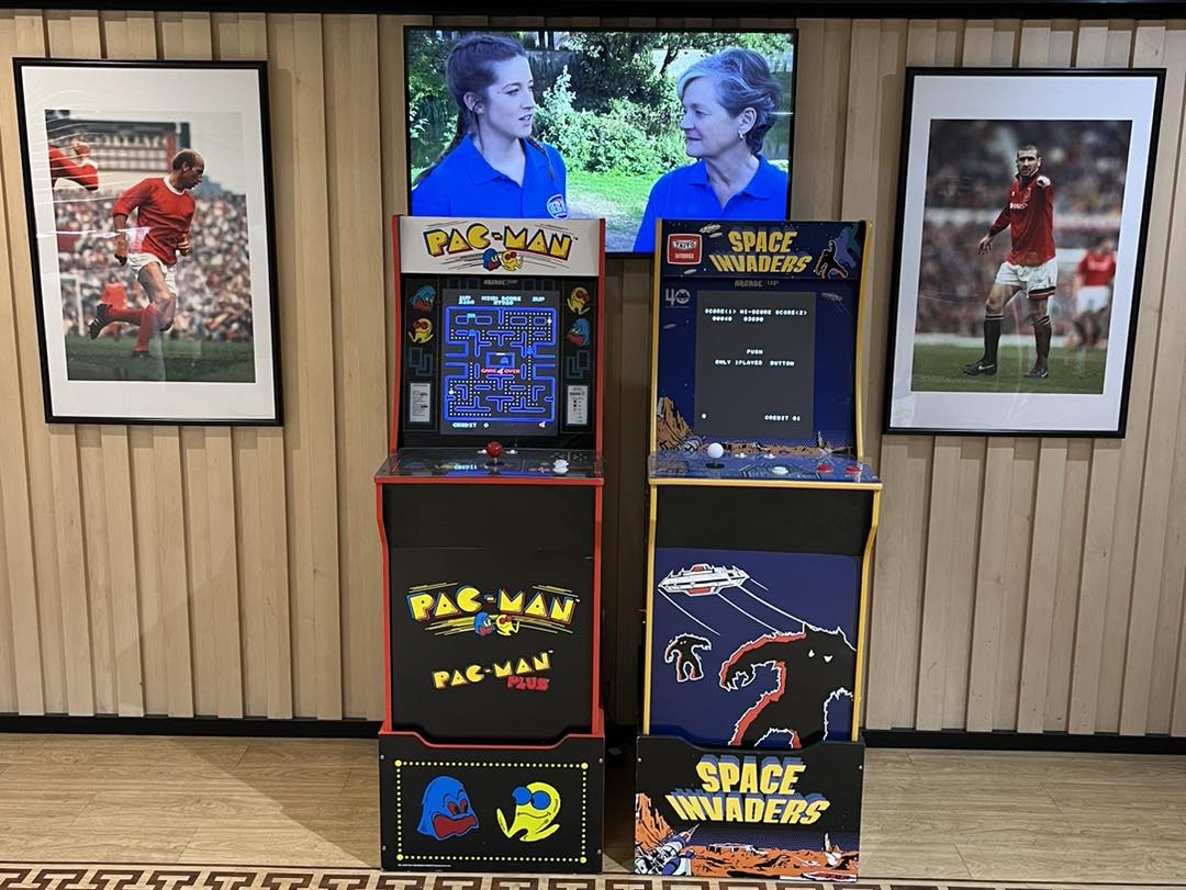 This image shows two retro arcade machines on hire at Old Trafford, home of Manchester United.