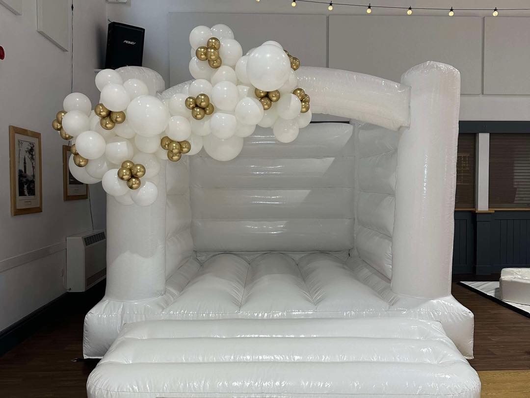 white bouncy castle with balloon garland